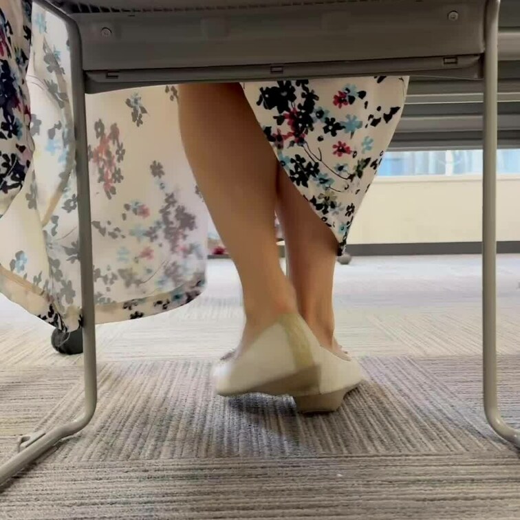 会議室。椅子の下の素足パンプス。