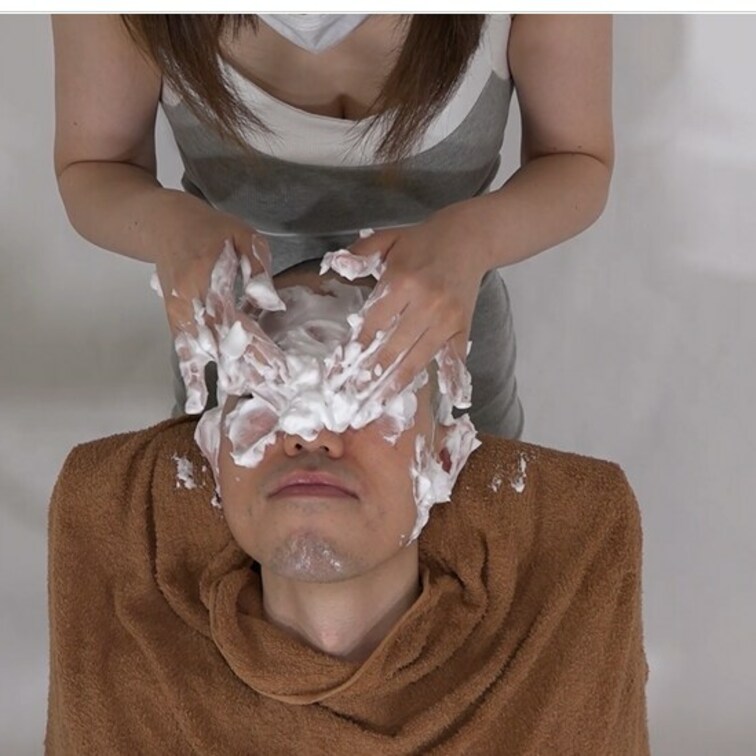男性の頭に泡をつけて洗う