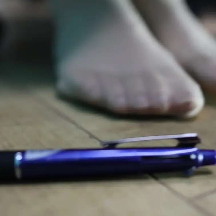ストッキングのつま先でボールペンを掴もうとする動画です