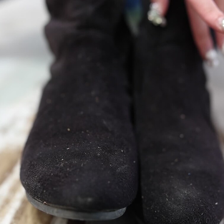 ニーハイブーツを脱いで黒ストッキングの足裏を見せて指をクネクネ動かす画像です。